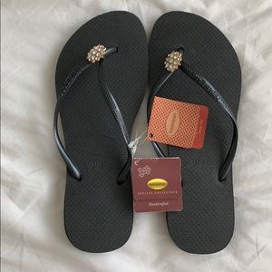 Black havaianas with gold and crystal detail.